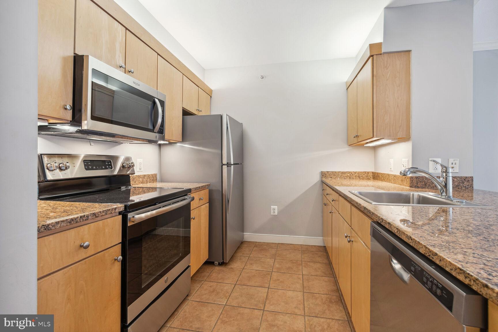 616 E Street Northwest, Unit 807 Washington, DC 20004 - Photo 7 of 24 a kitchen with stainless steel appliances granite countertop a sink stove and microwave