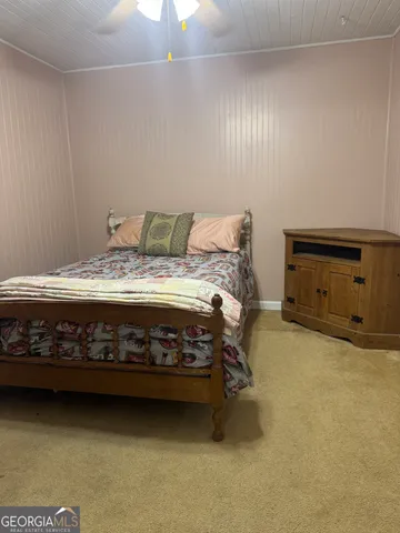 a bed sitting in a bedroom next to a lamp