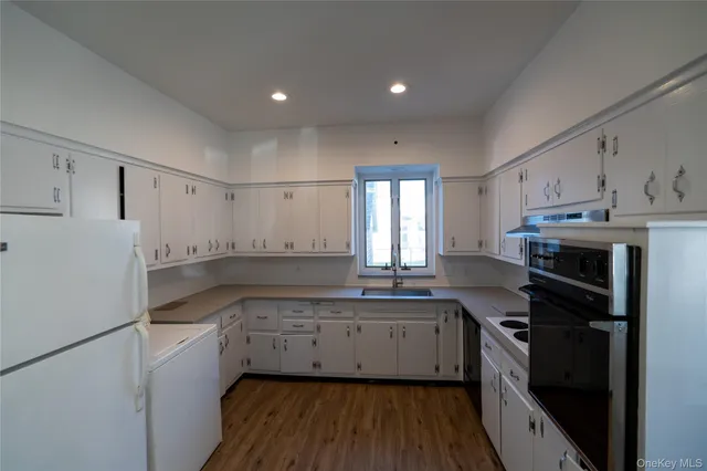 a kitchen with a refrigerator a sink and cabinets