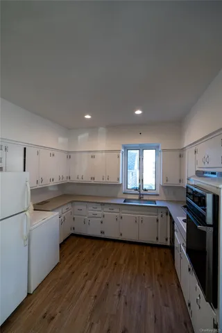 a kitchen with granite countertop a refrigerator stove and sink