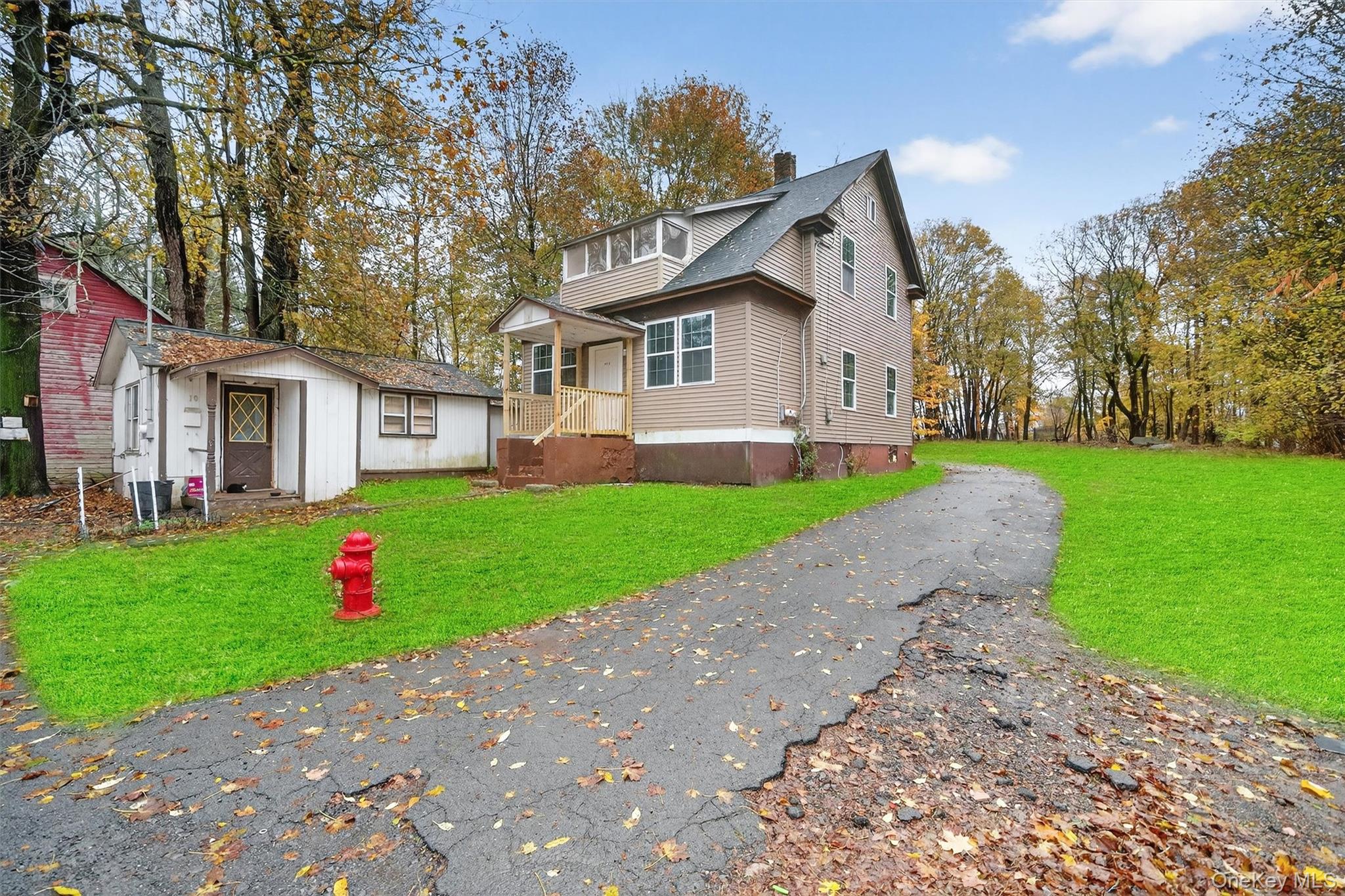 View of side of home with a lawn, asphalt driveway, and a chimney