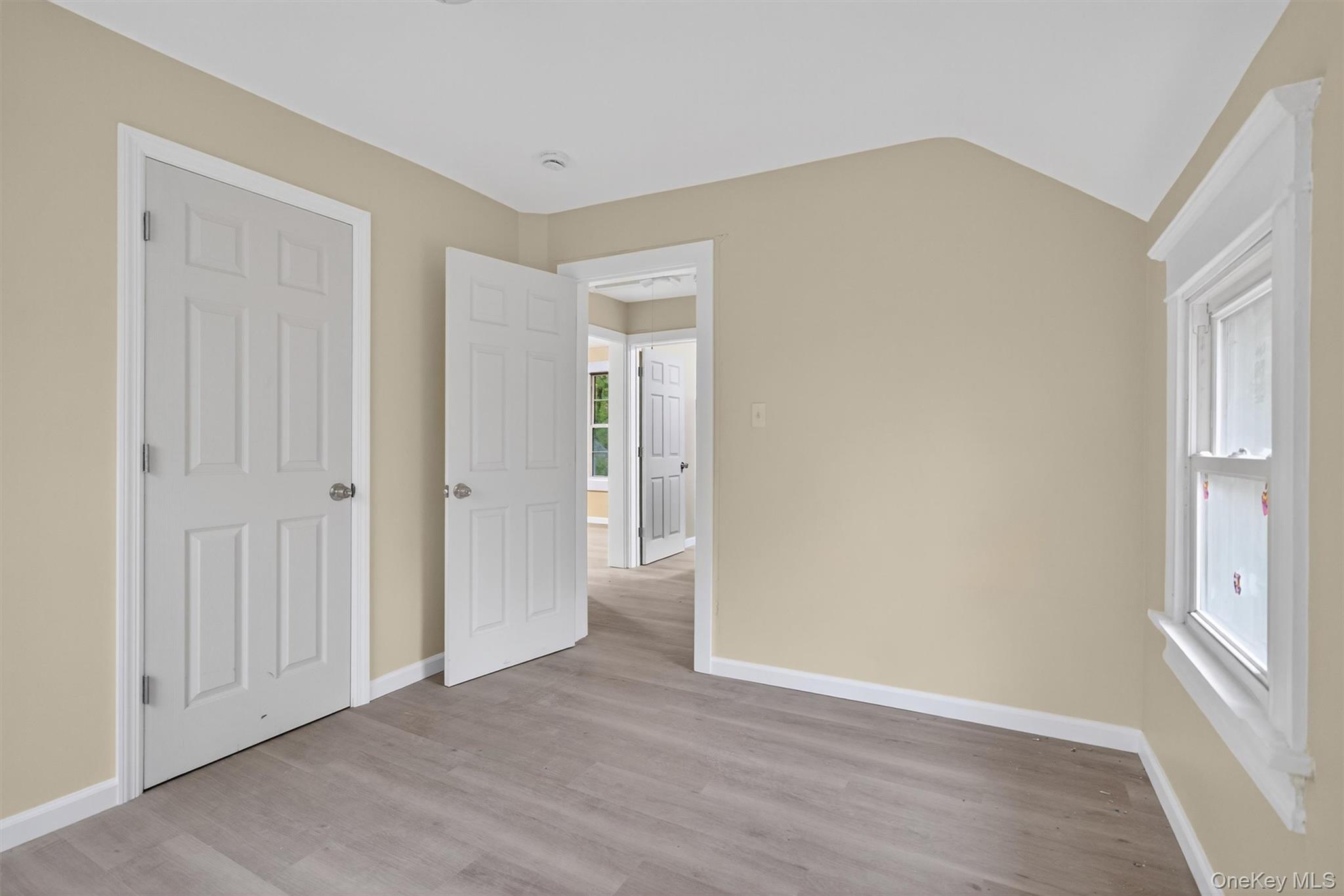 8 Cottage St Extension Monticello, NY 12701 - Photo 17 of 23 Unfurnished bedroom with light wood-style flooring and vaulted ceiling