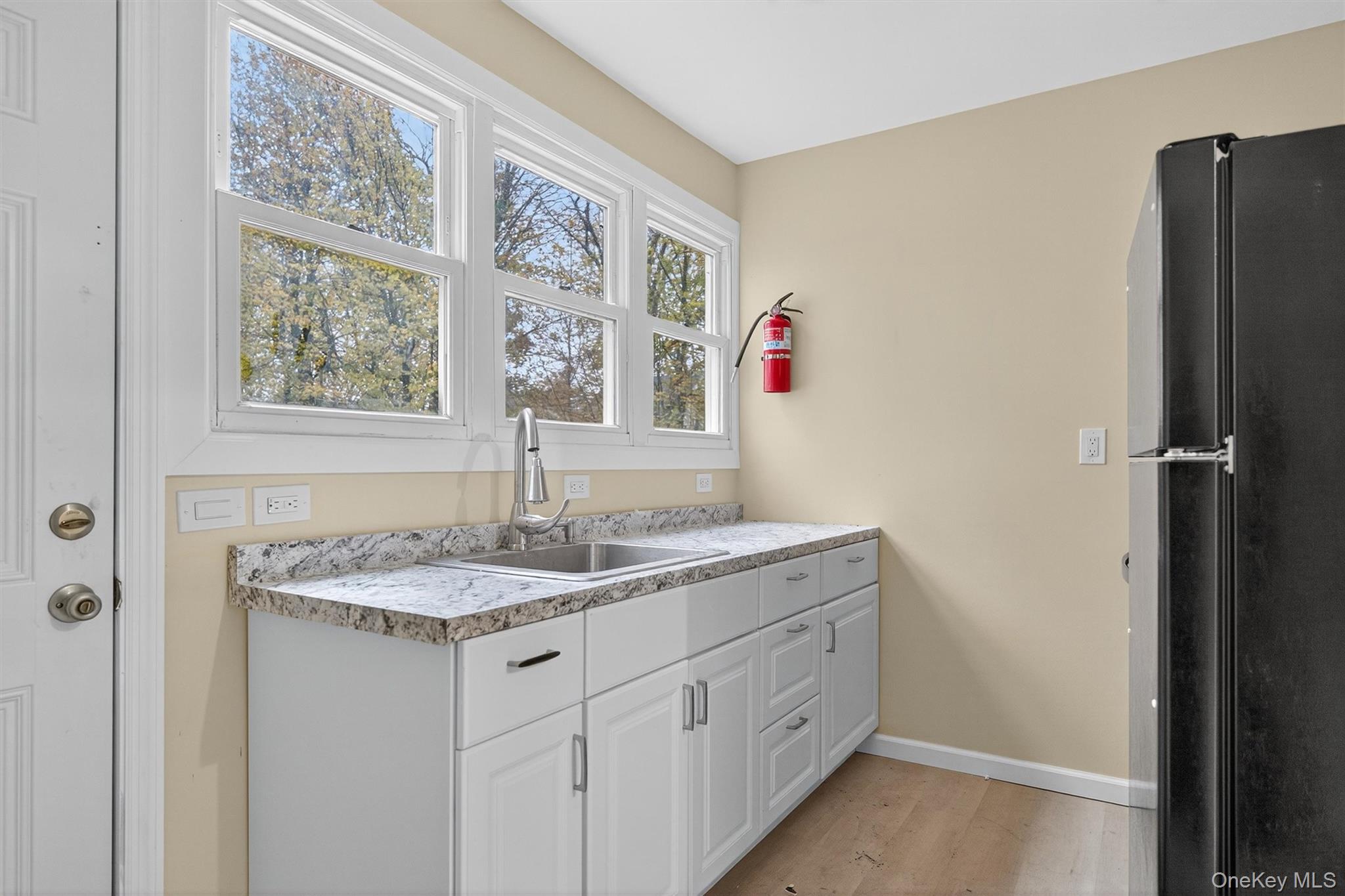 8 Cottage St Extension Monticello, NY 12701 - Photo 5 of 23 Kitchen featuring freestanding refrigerator, white cabinets, light wood-style flooring, and light countertops