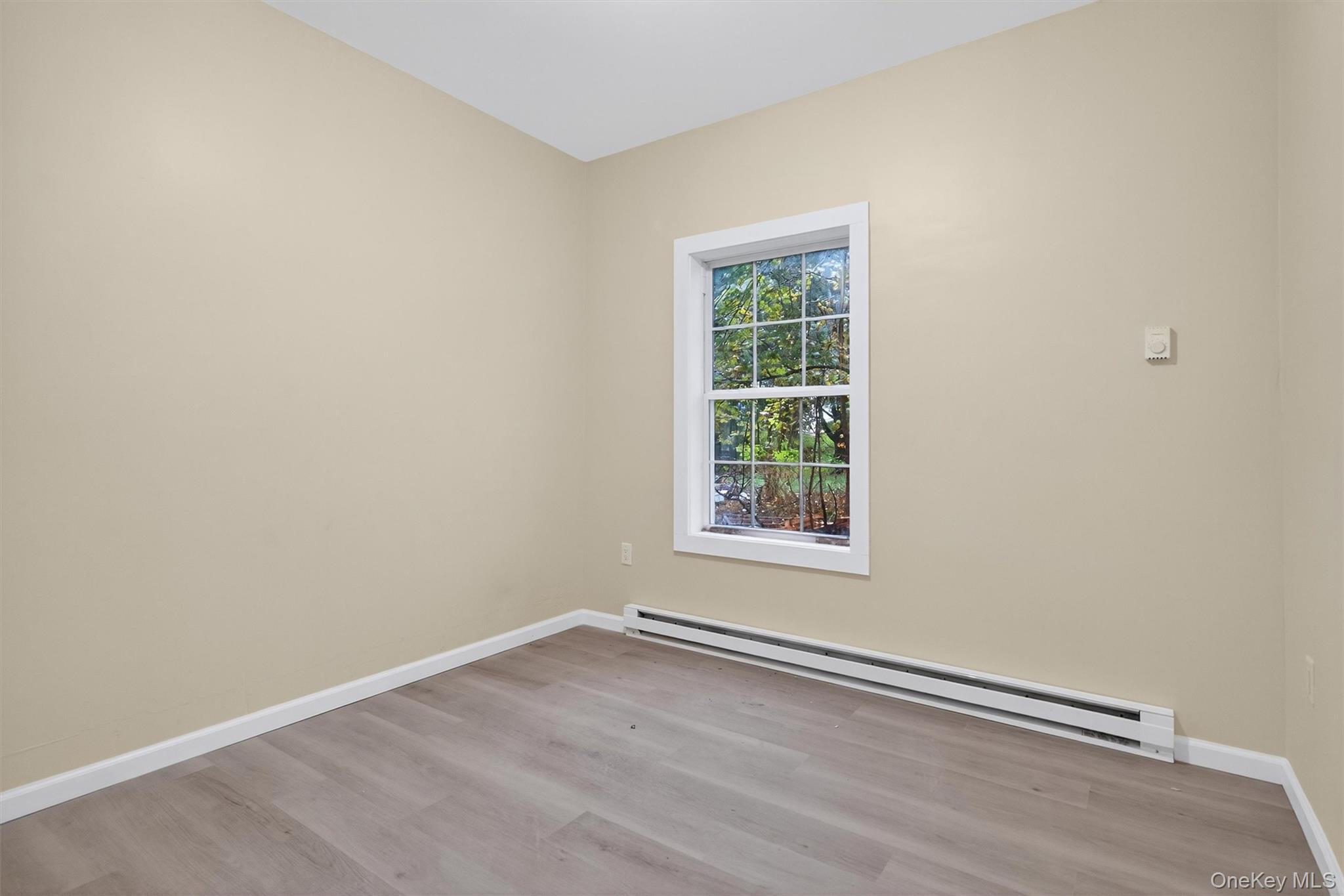8 Cottage St Extension Monticello, NY 12701 - Photo 10 of 23 Unfurnished room with a baseboard heating unit and light wood-style flooring