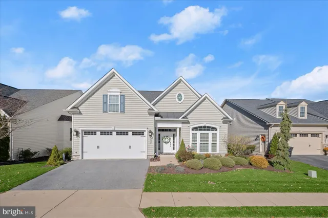 a front view of a house with a garden and yard