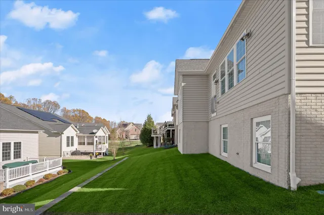 a view of a white house next to a yard with big trees