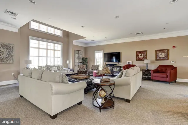 a living room with furniture a flat screen tv and a window