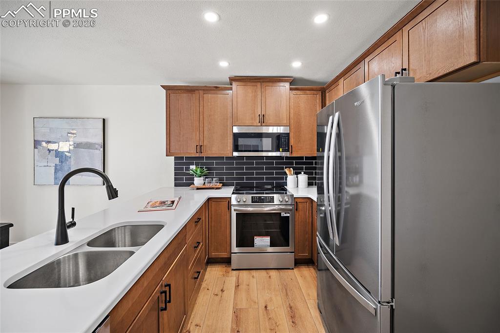 62 Rising Sun Terrace Colorado Springs, CO 80921 - Photo 13 of 46 a kitchen with stainless steel appliances a refrigerator sink and white cabinets