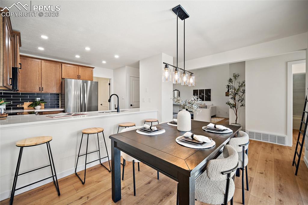 62 Rising Sun Terrace Colorado Springs, CO 80921 - Photo 3 of 46 a kitchen with stainless steel appliances kitchen island granite countertop a dining table chairs and white cabinets