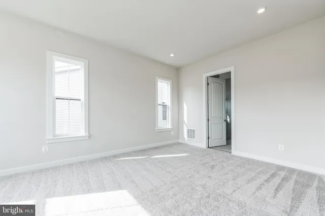 an empty room with windows and closet