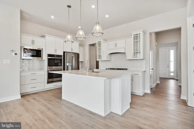 a large kitchen with cabinets and wooden floor