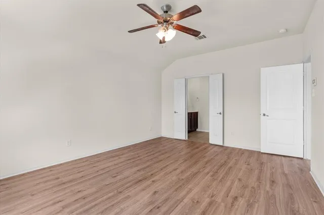 a view of an empty room with wooden floor