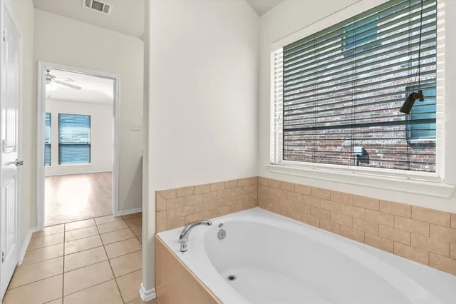 a bathroom with a bathtub and a window