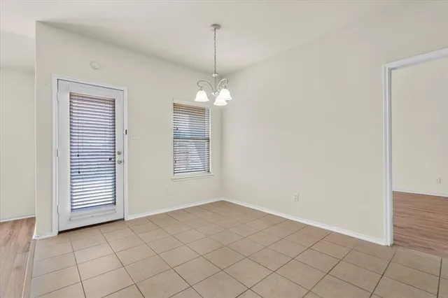 an empty room with windows and ceiling fan