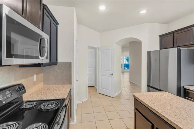 a kitchen with stainless steel appliances granite countertop a refrigerator and a stove