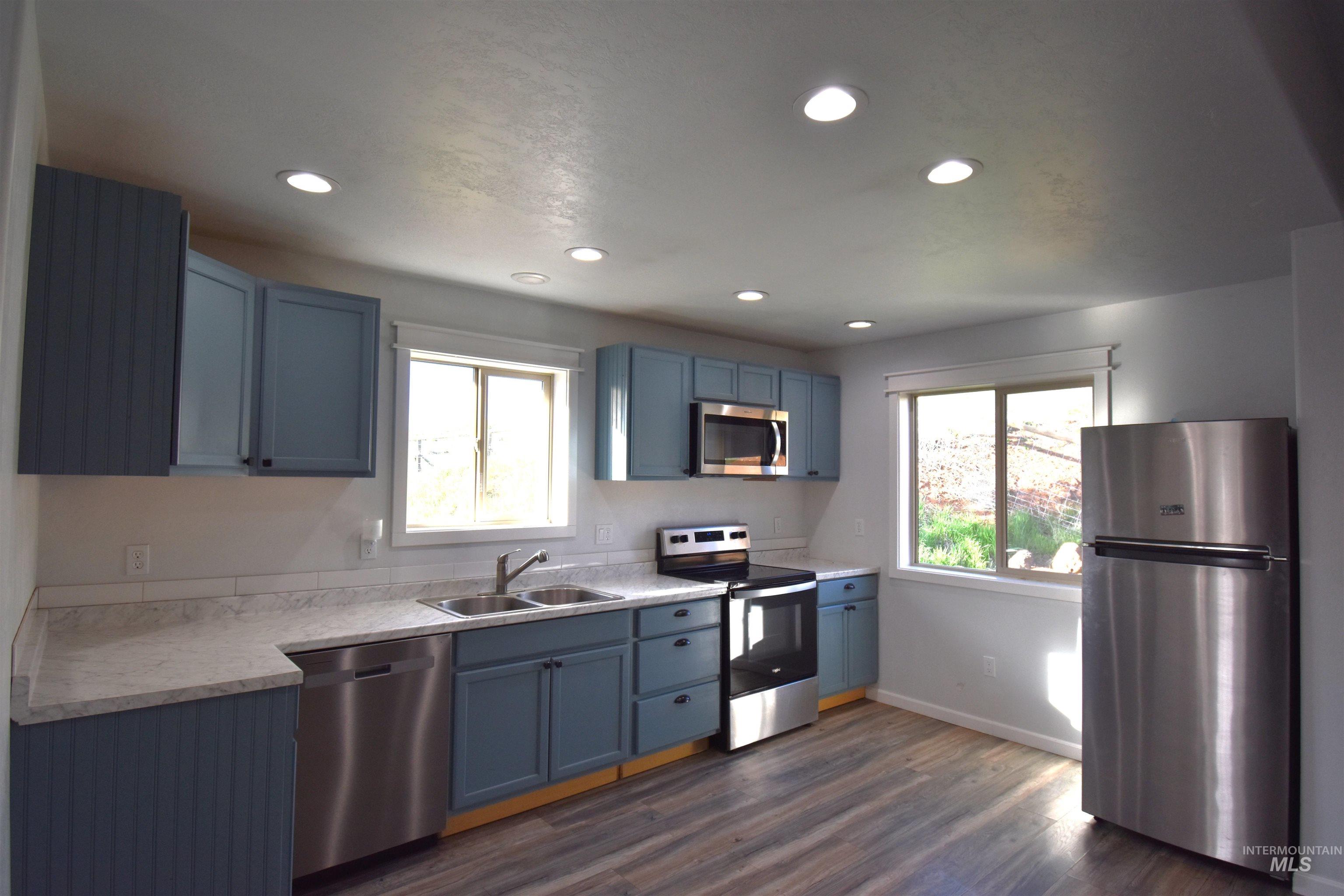 2599 Fruitvale Glendale Road Council, ID 83612 - Photo 3 of 29 Kitchen with light countertops, stainless steel appliances, dark wood finished floors, healthy amount of natural light, and recessed lighting