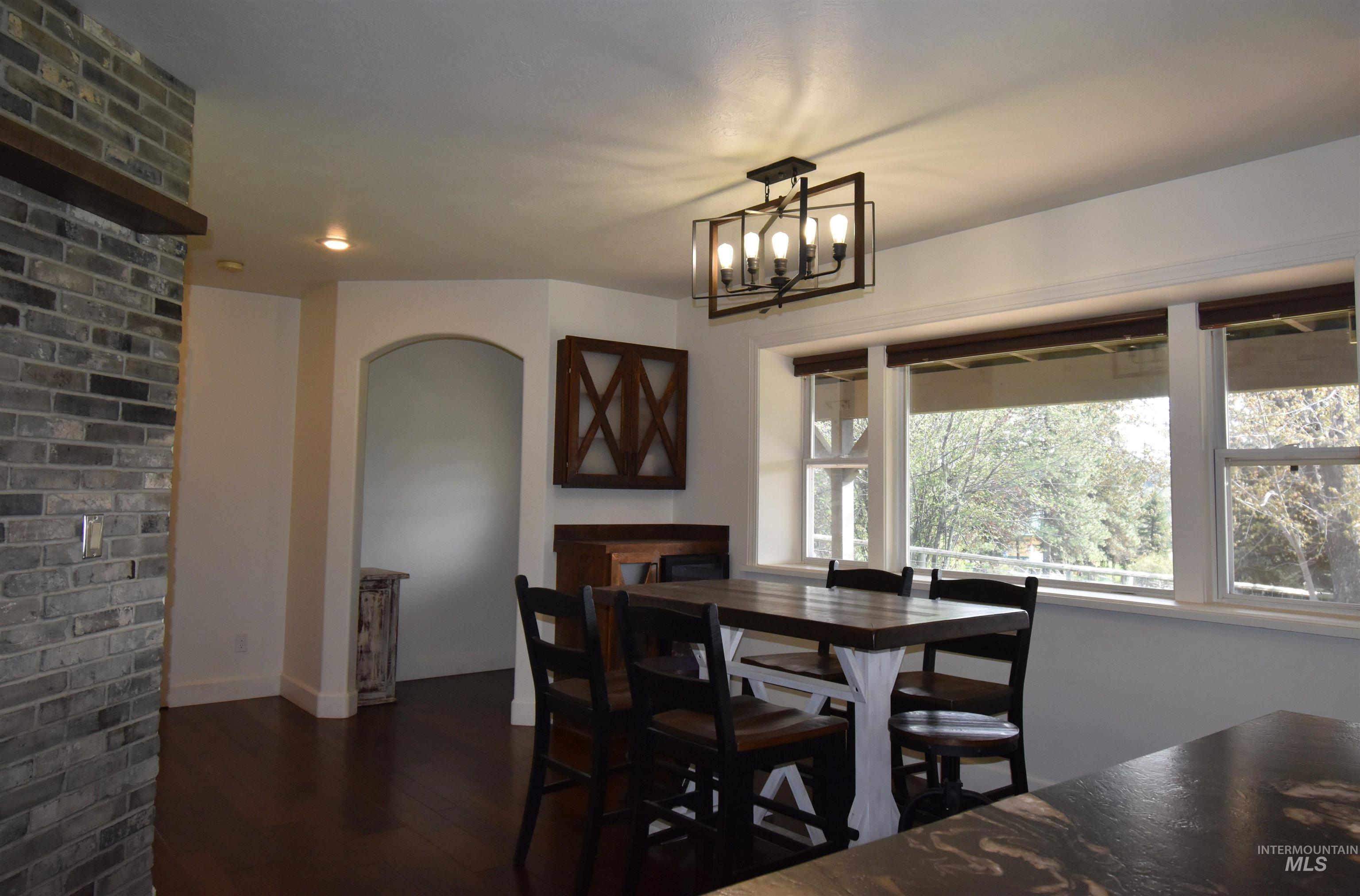 2599 Fruitvale Glendale Road Council, ID 83612 - Photo 5 of 38 Dining area featuring an arched entryway and a minibar with a beverage refrigerator.