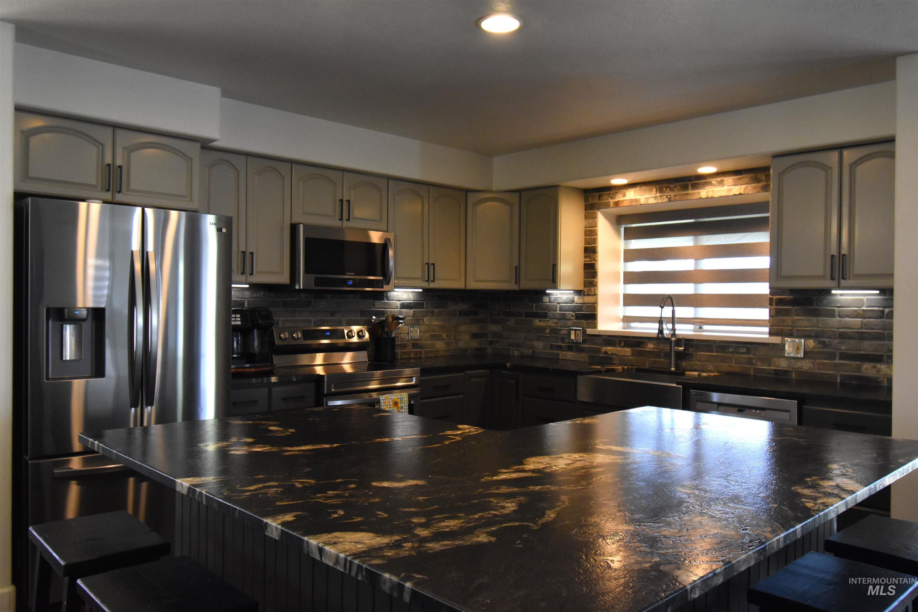 2599 Fruitvale Glendale Road Council, ID 83612 - Photo 7 of 38 Kitchen featuring a breakfast bar area, stainless steel appliances, recessed lighting, and tasteful brick backsplash.