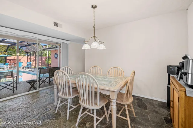 a dining room with furniture a chandelier and wooden floor