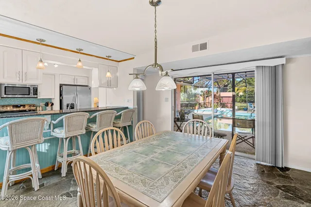 a dining room with furniture a chandelier and window