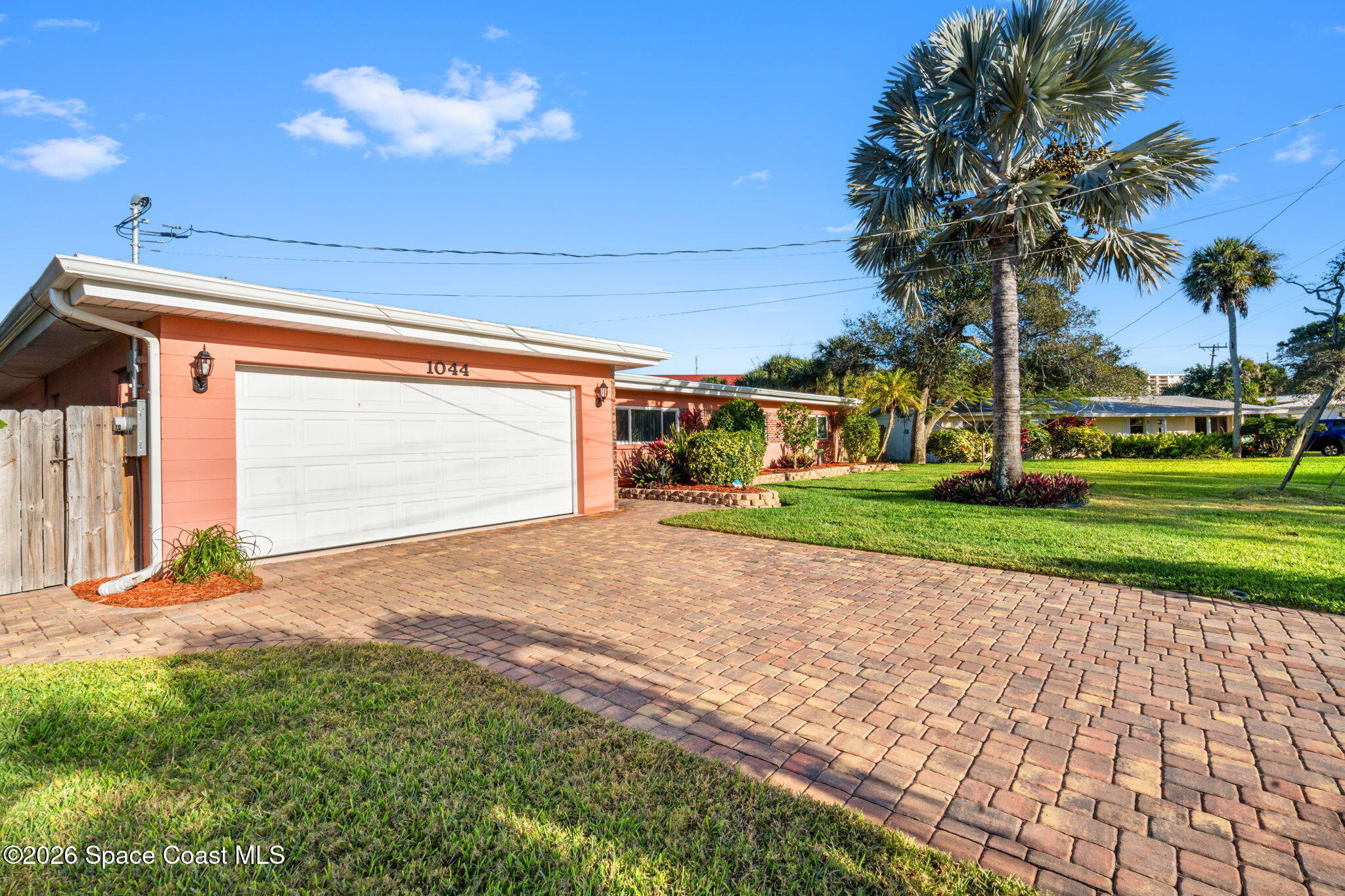 1044 Samar Road Cocoa Beach, FL 32931 - Photo 20 of 56 a front view of a house with a yard and garage