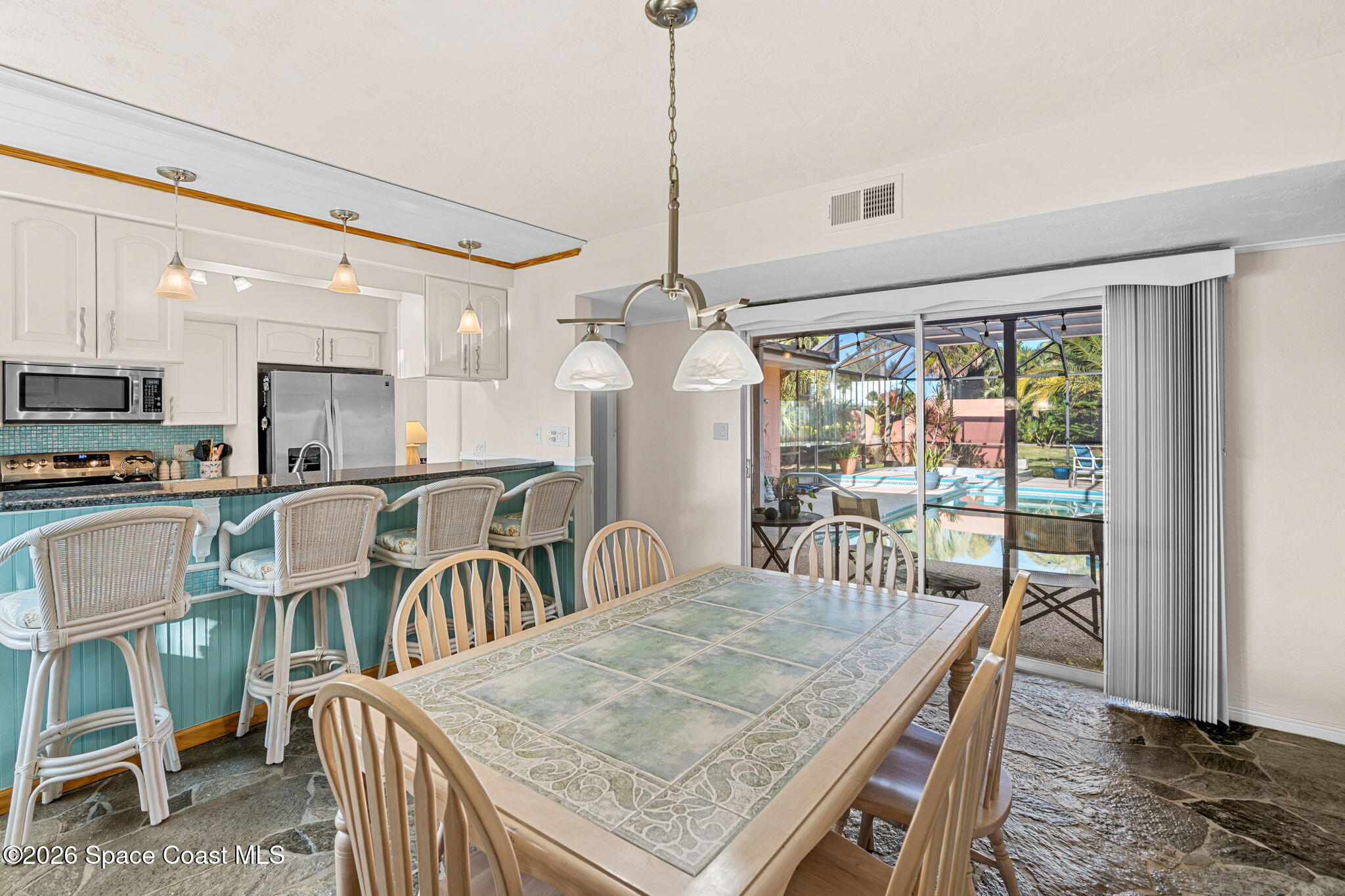 1044 Samar Road Cocoa Beach, FL 32931 - Photo 23 of 56 a dining room with furniture a chandelier and wooden floor