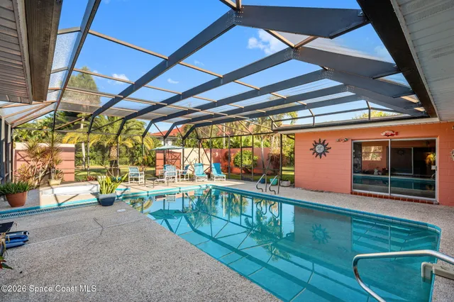 a view of a swimming pool with a patio and a yard