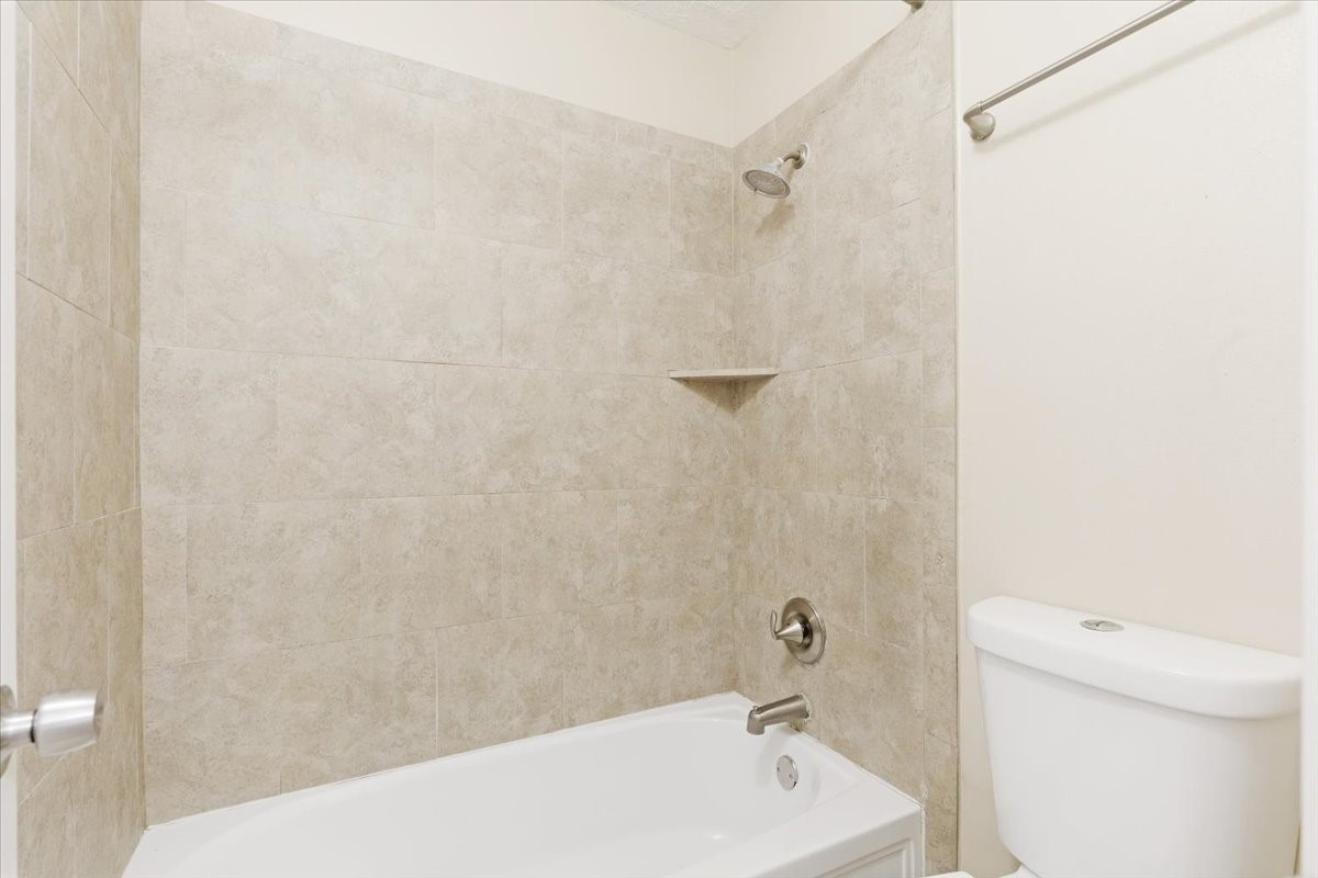 3502 Ocee Street, Unit 3502 Houston, TX 77063 - Photo 18 of 28 This bathroom features a clean, modern design with a tiled shower and bathtub combo. Neutral tones on the walls create a bright and inviting space.