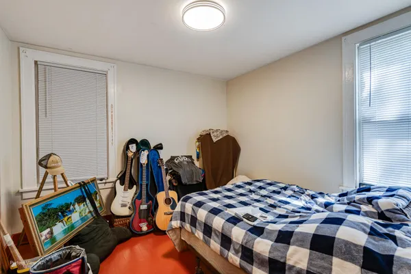 a bedroom with bed and wooden floor