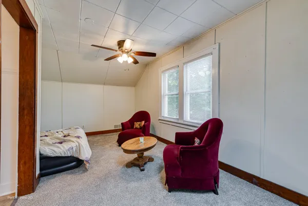 a living room with furniture a ceiling fan and a window