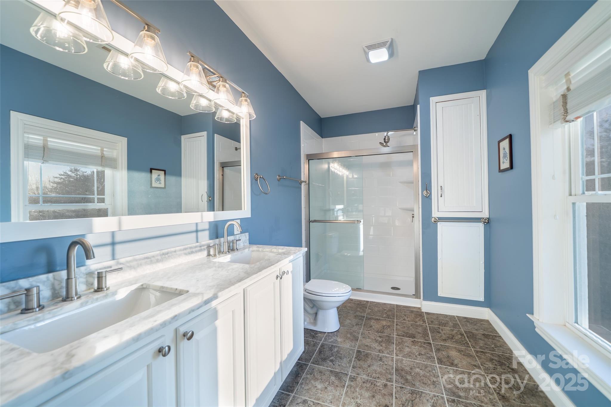 11 Forest Park Lane Asheville, NC 28803 - Photo 12 of 26 a bathroom with a sink a toilet a large mirror and shower
