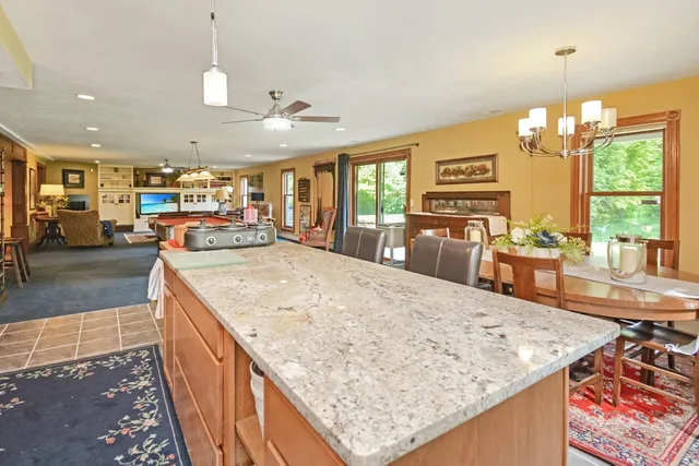 a kitchen with kitchen island granite countertop wooden cabinets and a sink