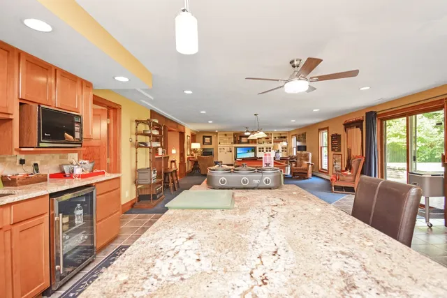 a kitchen with stainless steel appliances granite countertop a stove top oven a sink dishwasher and a dining table with the kitchen view