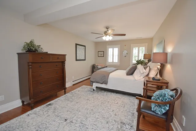 a living room with furniture stairs and a ceiling fan