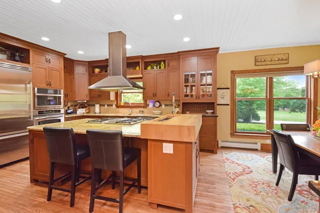 a living room with furniture kitchen view and a large window