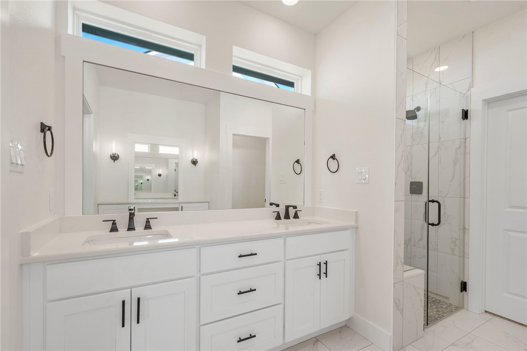 569 Harvest Lk Drive Snook, TX 77879 - Photo 12 of 22 Full bathroom with a marble finish shower, double vanity, and light marble finish floors