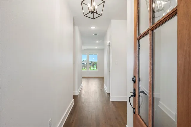 a view of a hallway with wooden floor and closet