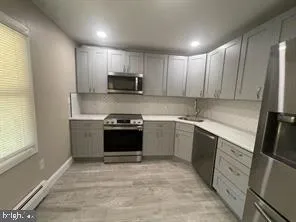 a kitchen with a sink white cabinets and stainless steel appliances