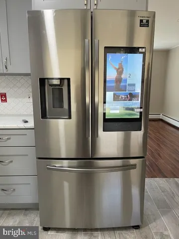 a view of a refrigerator in kitchen and wooden floor