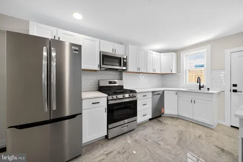 a kitchen with stainless steel appliances and refrigerator