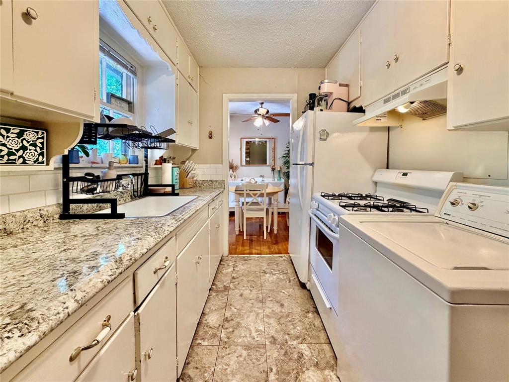 919 Denton Street Denton, TX 76201 - Photo 8 of 19 a kitchen with kitchen island granite countertop lots of counter top space and stainless steel appliances