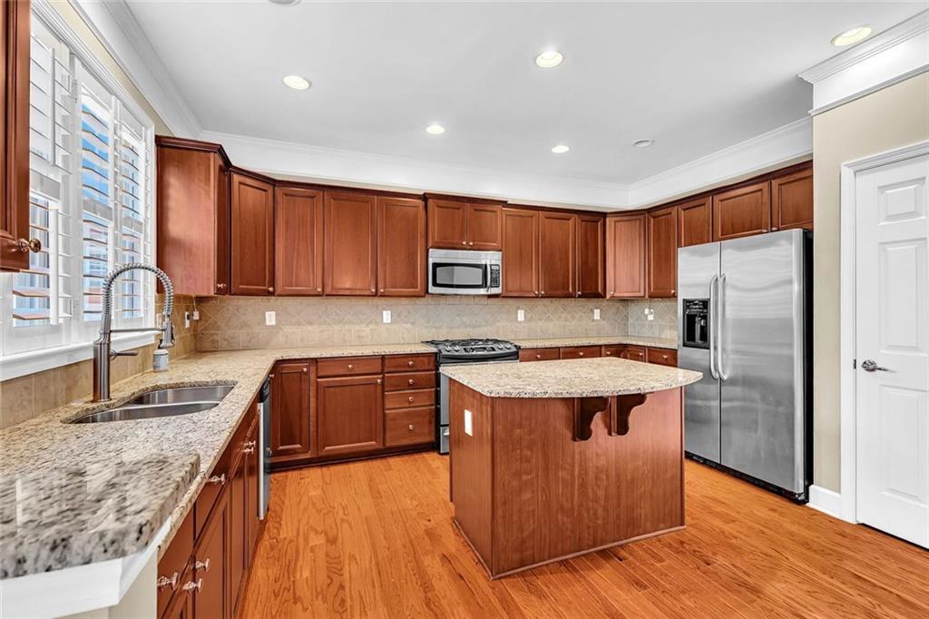 4888 Colchester Court, Unit 163 Atlanta, GA 30339 - Photo 13 of 44 a kitchen with stainless steel appliances granite countertop wooden cabinets a stove top oven and granite counter tops