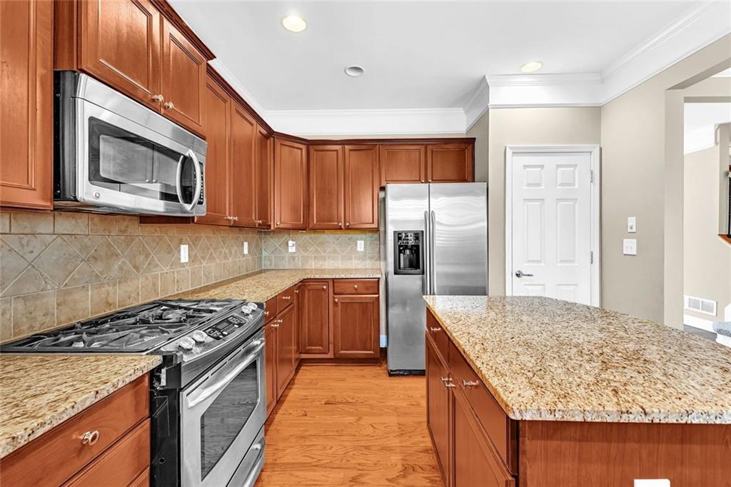 4888 Colchester Court, Unit 163 Atlanta, GA 30339 - Photo 14 of 44 a kitchen with stainless steel appliances granite countertop a stove refrigerator and microwave