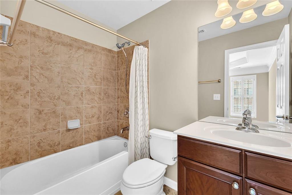 4888 Colchester Court, Unit 163 Atlanta, GA 30339 - Photo 23 of 44 a bathroom with a sink a toilet a mirror a bathtub and shower