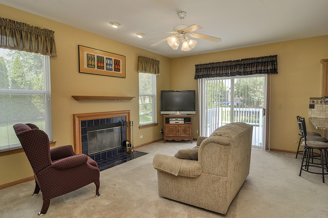1056 Teasel Lane Aurora, IL 60504 - Photo 12 of 25 a living room with furniture a fireplace and a flat screen tv