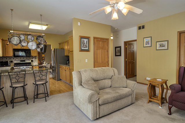 1056 Teasel Lane Aurora, IL 60504 - Photo 13 of 25 a living room with furniture a flat screen tv and kitchen view