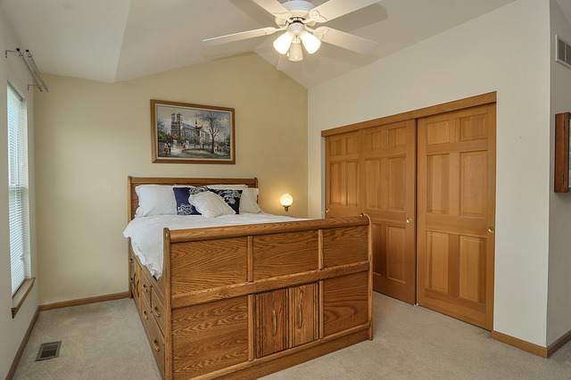 1056 Teasel Lane Aurora, IL 60504 - Photo 14 of 25 a bedroom with a bed and a chandelier
