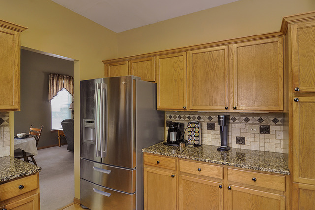 1056 Teasel Lane Aurora, IL 60504 - Photo 10 of 25 a kitchen with granite countertop a refrigerator and a sink