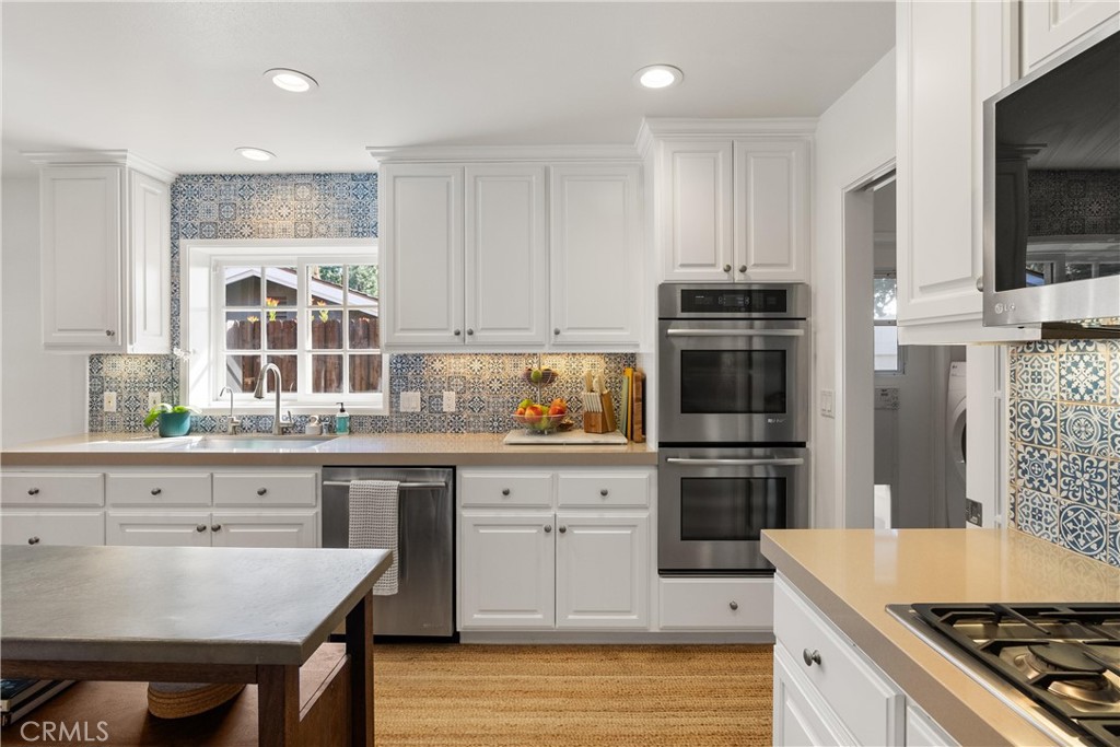 10442 Boca Canyon Drive North Tustin, CA 92705 - Photo 35 of 55 a kitchen with granite countertop a stove a sink and a refrigerator