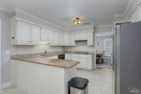 a kitchen with granite countertop white cabinets and white appliances